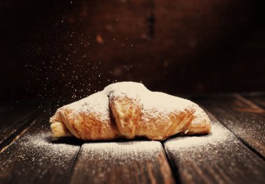 kruvasan ahşap masa üzerine pudra şekeri ile