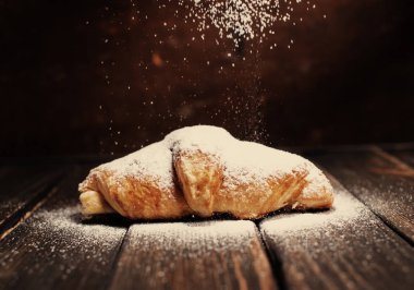 kruvasan ahşap masa üzerine pudra şekeri ile