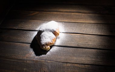 kruvasan ahşap masa üzerine pudra şekeri ile