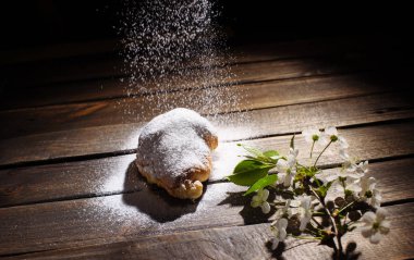 kruvasan düşen pudra şekeri ile ahşap masa