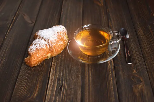 Kruvasan ile çay ahşap masa — Stok fotoğraf