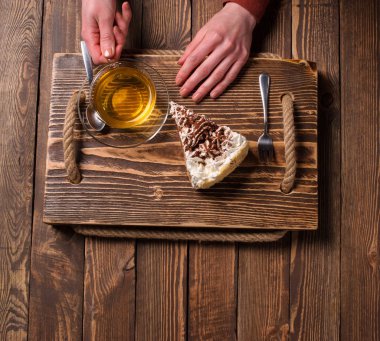 çay ve pasta ahşap masa üzerinde elleriyle