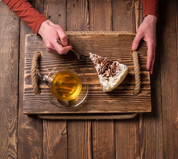 çay ve pasta ahşap masa üzerinde elleriyle