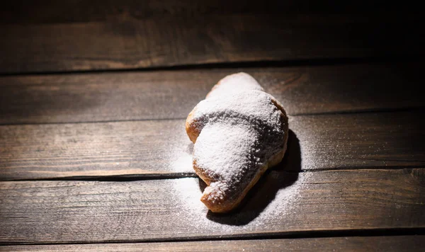 kruvasan ahşap masa üzerine pudra şekeri ile