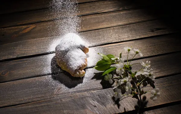 kruvasan düşen pudra şekeri ile ahşap masa