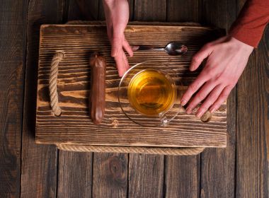 çay ve pasta ahşap masa üzerinde elleriyle