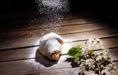 kruvasan düşen pudra şekeri ile ahşap masa