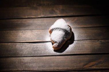 kruvasan ahşap masa üzerine pudra şekeri ile
