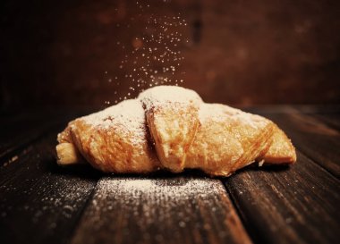 kruvasan ahşap masa üzerine pudra şekeri ile