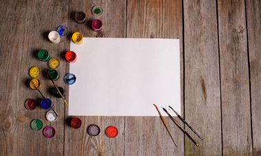 Kağıt, sulu boya, boya fırçası ve bazı sanat şeyler ahşap sekmesinde