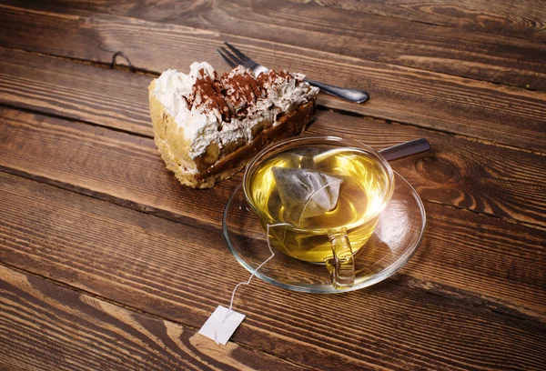 Pastel con té en escritorio de madera — Foto de Stock