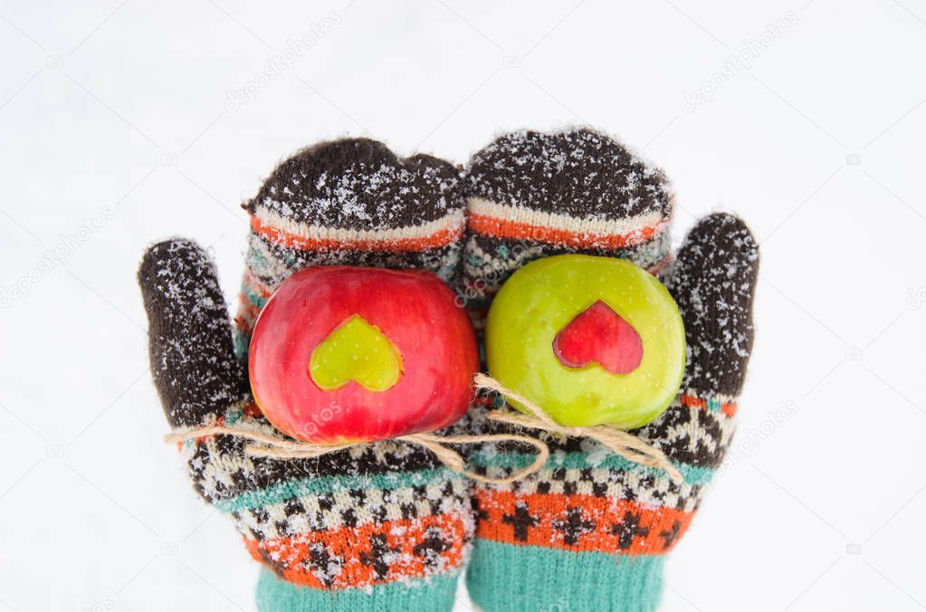 apples with hearts in hands in winter