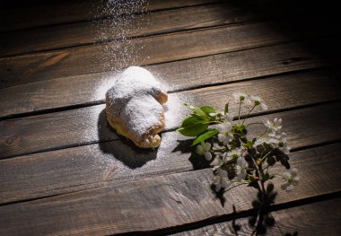 kruvasan düşen pudra şekeri ile ahşap masa