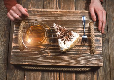 çay ve pasta ahşap masa üzerinde elleriyle