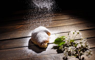 kruvasan ahşap masa üzerine pudra şekeri ile