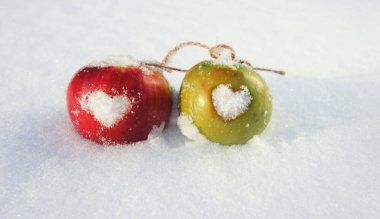 Kırmızı ve yeşil elma ile kar üzerinde hearts
