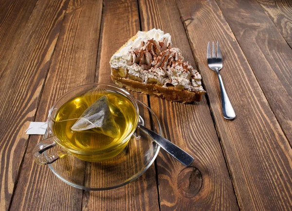 Pastel con té en escritorio de madera — Foto de Stock