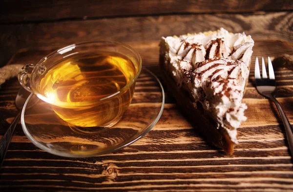 Gâteau avec thé sur bureau en bois — Photo