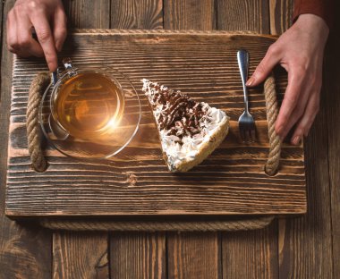 çay ve pasta ahşap masa üzerinde elle. Üstten Görünüm