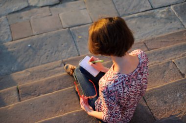 Not defterine kalem yazan kadın eller