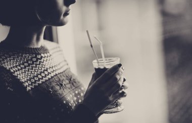 Bir pencere yanında duran, kırmızı kış giysileri giyiyor ve içme güzel kadın mulled şarap