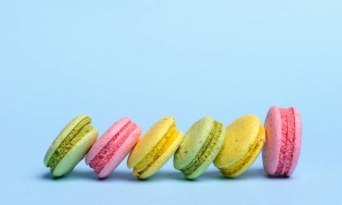 Tatlı ve renkli Fransızca macaroons veya mavi zemin üzerine macaron