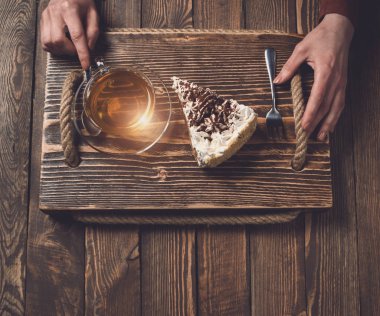 çay ve pasta ahşap masa üzerinde elle. Üstten Görünüm