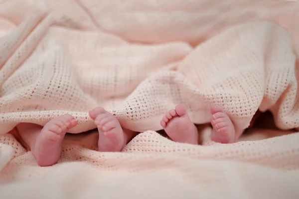 twins feet on a white blanket