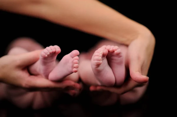 Matka drží předčasné dvojčata nohy — Stock fotografie