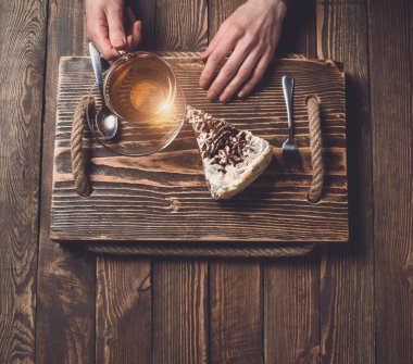 çay ve pasta ahşap masa üzerinde elleriyle