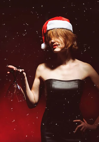 クリスマス プレゼント サンタの帽子でモデルの女の子 シャンパンと赤の背景に分離したガラスを保持している少女 年末年始 — ストック写真