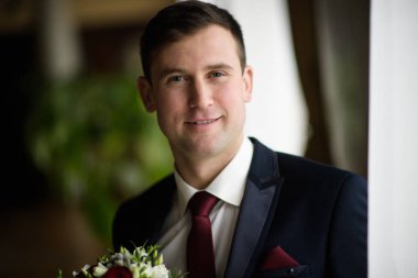 Smokin papyon konumu ile olan kendine güvenen genç adam ceplerinde eller