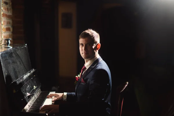 Confident young man is playing piano