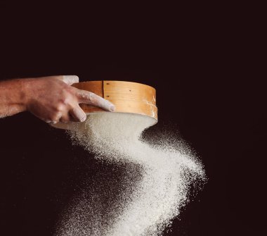 Şef un siyah arka plan üzerinde sifts.