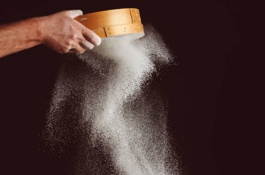 Şef un siyah arka plan üzerinde sifts.