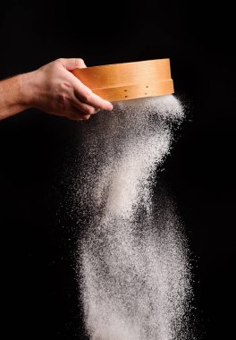 Şef un siyah arka plan üzerinde sifts.