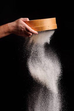 Şef un siyah arka plan üzerinde sifts.