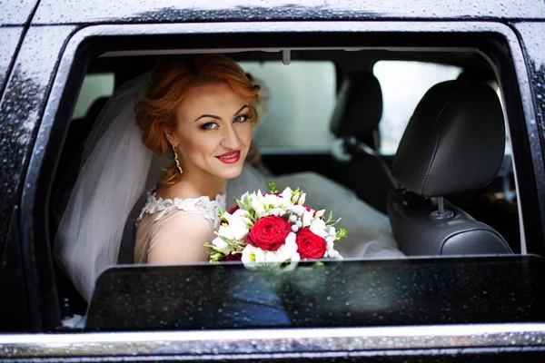 車の中の花の花束と美しい花嫁 — ストック写真