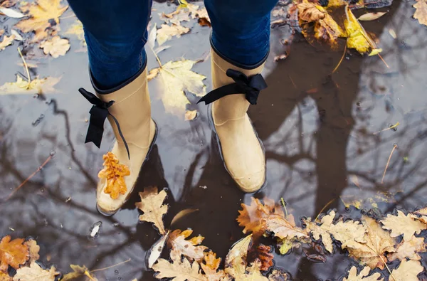 秋紅葉のコンセプトと長靴の外 ブーツで歩く女足のクローズ アップ — ストック写真