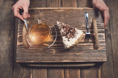 çay ve pasta ahşap masa üzerinde elle. Üstten Görünüm