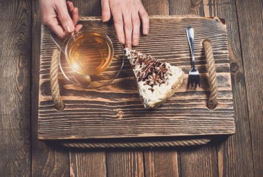 çay ve pasta ahşap masa üzerinde elleriyle