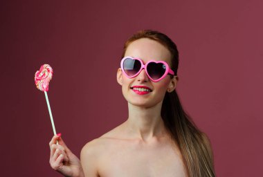 bir lolipop Studio pembe arka plan üzerinde ile duygusal seksi kız