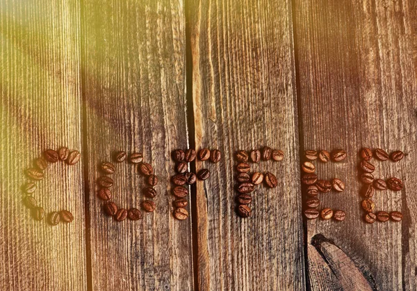Λέξη Καφέ Φτιαγμένο Από Κόκκους Καφέ Φόντο Ξύλινη — Φωτογραφία Αρχείου