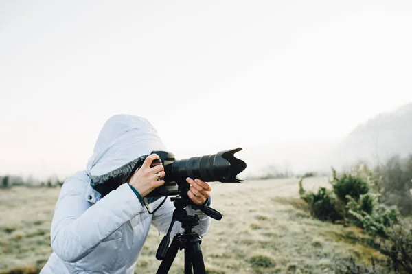 Фотограф с фотоаппаратом и штативом на открытом воздухе — стоковое фото