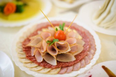 Tatil masasında farklı sosis çeşitleri olan tabaklar.