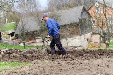 Atlarla tarlayı süren adam.