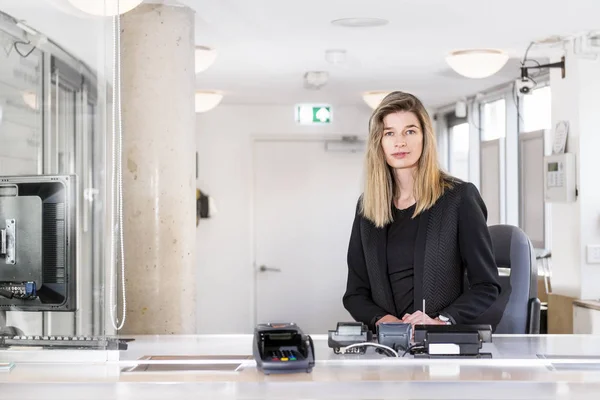 Saleswoman behind a ticket counter — Stock Photo, Image