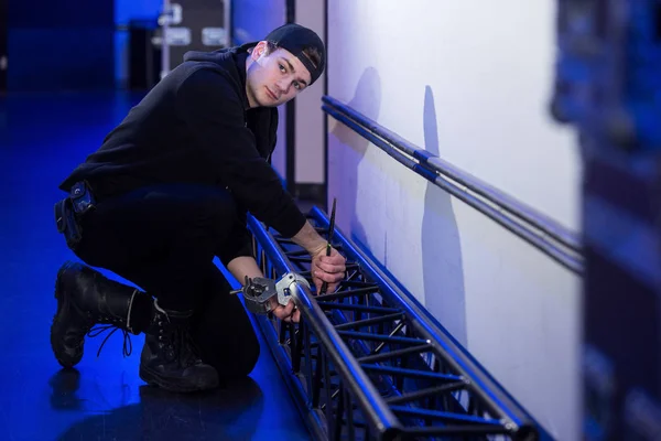 Roadie montando uma braçadeira em uma treliça — Fotografia de Stock