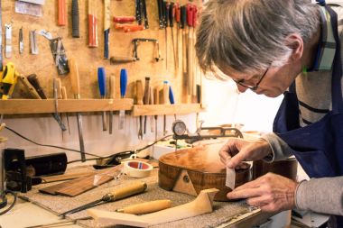 Instrument maker masking a guitar  with tape clipart