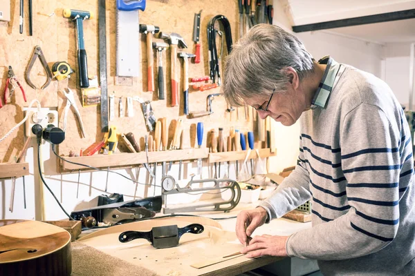 Luthier drawing the outline of a lute piece — Stock Photo, Image